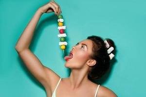 femme heureuse avec un maquillage coloré et des bonbons sucrés sur une brochette photo