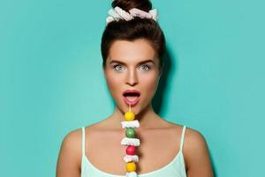 femme heureuse avec un maquillage coloré et des bonbons sucrés sur une brochette photo