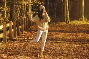 jeune et heureuse femme dans le parc à la journée d'automne ensoleillée photo