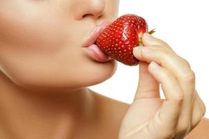 gros plan des lèvres féminines avec une fraise photo