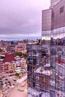 new york city - 12 août 2017 - vue sur l'horizon de manhattan reflétée contre l'hôtel bowery dans le quartier chinois le soir à l'approche du crépuscule. photo