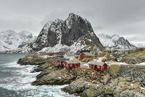 cabane de pêche dans le sommet de la montagne hamnoy et lilandstinden en hiver à reine, îles lofoten, norvège. photo
