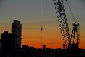 construction sur fond de silhouette de la ville de new york au coucher du soleil. photo