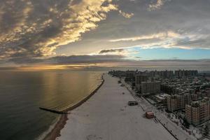 Vue aérienne d'une plage couverte de neige de Coney Island pendant l'hiver au coucher du soleil à Brooklyn, New York photo