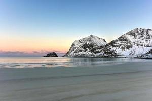 aube sur la plage de haukland, îles lofoten, norvège en hiver. photo