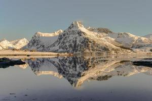 boosen par bo avec des montagnes se reflétant dans l'eau. dans les îles lofoten, norvège en hiver. photo