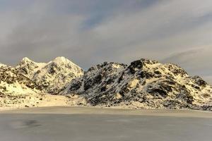 lac enneigé vikvatnet dans les îles lofoten, norvège en hiver. photo
