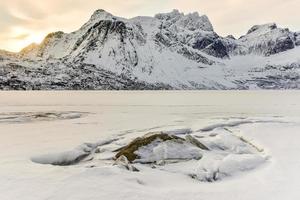 lac enneigé storvatnet dans les îles lofoten, norvège en hiver. photo