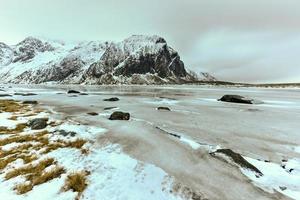 plage de galets pittoresque à eggum, îles lofoten, arctique, norvège, scandinavie, europe par une journée d'hiver nuageuse. photo