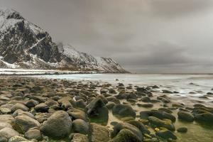 plage de galets pittoresque à eggum, îles lofoten, arctique, norvège, scandinavie, europe par une journée d'hiver nuageuse. photo