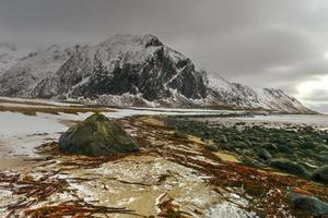 plage de galets pittoresque à eggum, îles lofoten, arctique, norvège, scandinavie, europe par une journée d'hiver nuageuse. photo