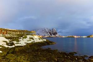 hiver à reine, îles lofoten, norvège. stocks pour le séchage du poisson la nuit. photo