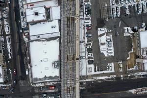 vue aérienne d'un train traversant des voies ferrées surélevées couvertes de neige s'étendant de coney island, brooklyn, new york. photo