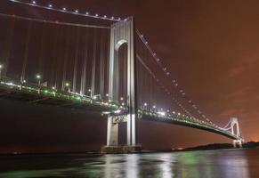 verrazano rétrécit le pont la nuit depuis brooklyn. le pont un pont suspendu à deux étages qui relie les arrondissements de staten island et de brooklyn à new york city au passage étroit. photo