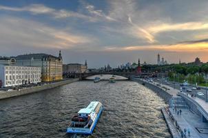 bateau de croisière naviguant le long de la rivière moskva, moscou, russie au coucher du soleil. photo