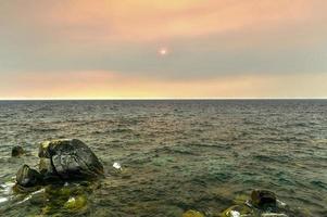 crique secrète le long du lac tahoe au nevada avec un ciel brumeux en raison des incendies de forêt à proximité en californie. photo