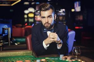 bel homme jouant à la roulette dans le casino photo