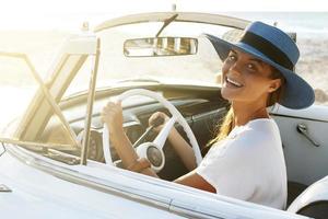 belle femme au chapeau bleu et cabriolet rétro blanc photo