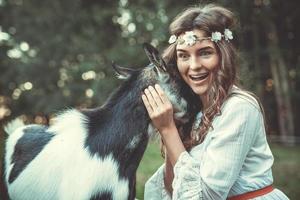 belle femme avec une drôle de chèvre amicale dans le village photo