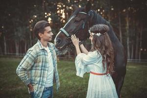 jeune couple prenant soin de beau cheval photo