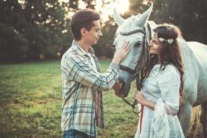 jeune couple prenant soin de beau cheval photo