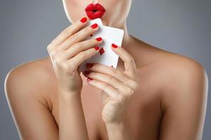 femme aux lèvres rouges tient deux as. photo