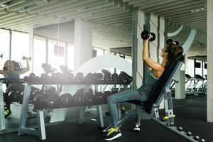 femme travaillant avec des haltères dans la salle de gym photo