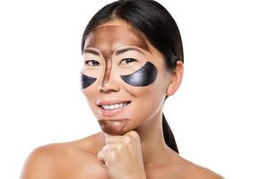 jeune femme asiatique avec un masque peel-off purifiant sur son visage photo