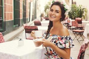 femme heureuse assise dans le café de la rue avec une tasse de café chaud photo