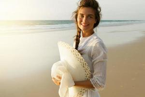 portrait de belle jeune femme avec un chapeau à larges bords sur la plage photo