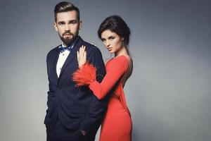 femme en belle robe rouge et homme portant un costume classique bleu avec noeud papillon. photo