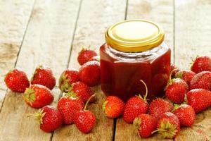 baies et confiture de fraise sucrée sur table en bois photo