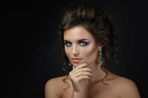 femme avec un beau maquillage et coiffure portant des boucles d'oreilles brillantes photo