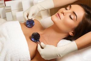 femme dans un salon de beauté pendant le traitement avec des boules de verre froides photo