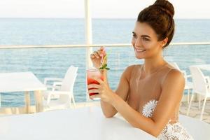 femme en belle robe avec un verre de cocktail photo