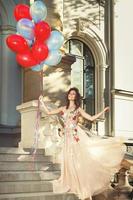 femme en belle robe avec beaucoup de ballons colorés photo