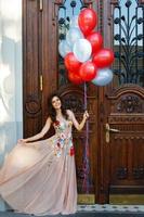 femme en belle robe avec beaucoup de ballons colorés photo