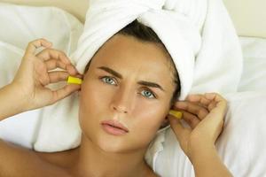 femme dans la chambre à l'aide de bouchons d'oreilles pour dormir photo