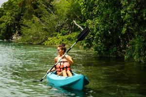 heureuse jeune femme faisant du kayak sur le lac photo