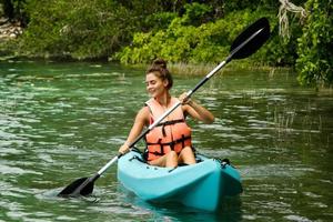 heureuse jeune femme faisant du kayak sur le lac photo