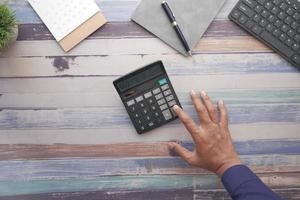 vue de dessus de la main de l'homme à l'aide de la calculatrice photo