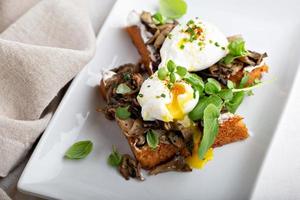 pain grillé au petit-déjeuner avec champignons et œufs pochés photo