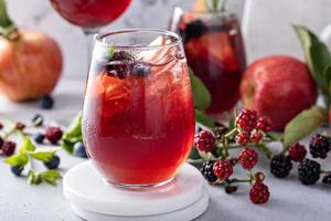 sangria aux baies d'automne et aux pommes dans un verre avec de la glace photo