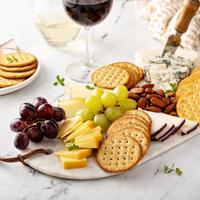 plateau de fromages avec craquelins, noix et raisins photo