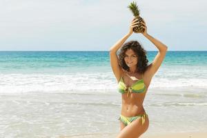 femme avec un fruit d'ananas sur la plage photo