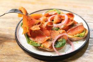 délicieux toasts au saumon fumé, avocat et feuilles de basilic photo