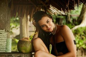 une femme heureuse profite d'une boisson à la noix de coco au bar de la plage photo