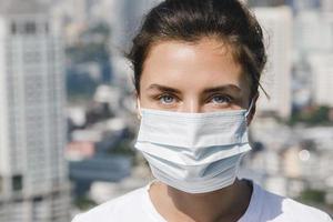 femme portant un masque facial à cause de la pollution de l'air ou de la pandémie de virus dans la ville photo