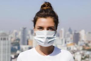 femme portant un masque facial à cause de la pollution de l'air ou de la pandémie de virus dans la ville photo