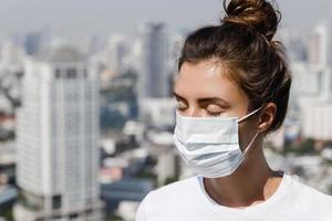 femme portant un masque facial à cause de la pollution de l'air ou de la pandémie de virus dans la ville photo